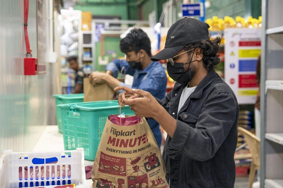 Flipkart Minutes worker preparing an order inside a micro-fulfilment centre for quick commerce delivery.